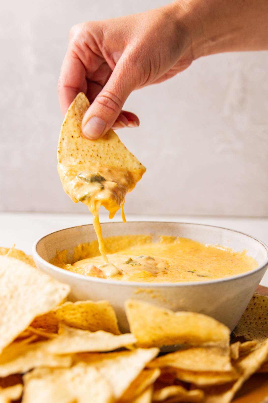 Tortilla chip dipping in cheese dip