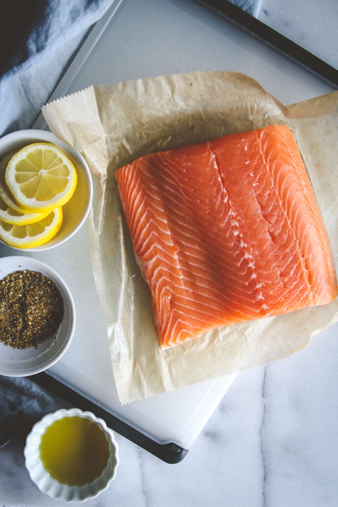Salmon filet with lemon, spices and olive oil on the side
