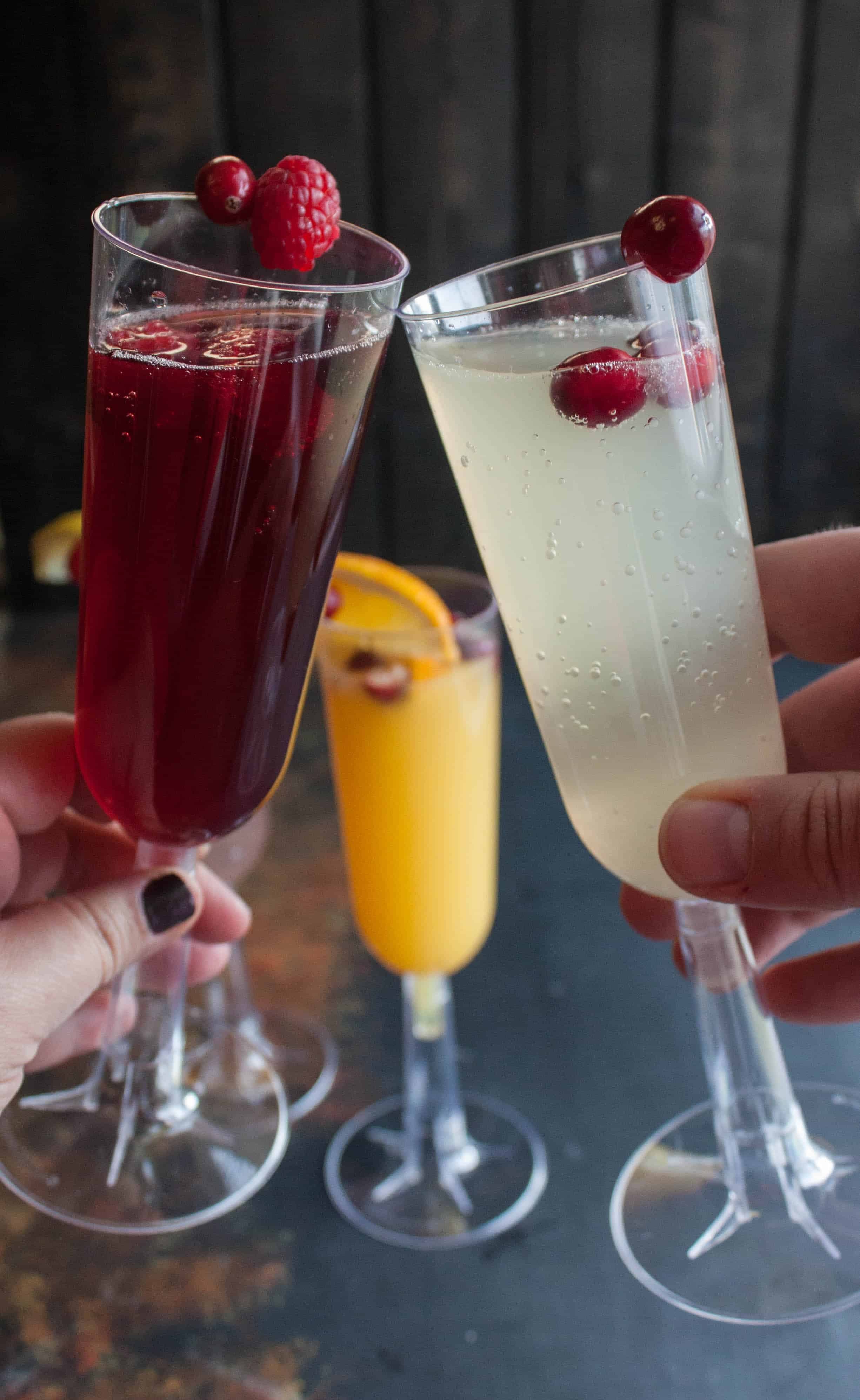 Cheers with two champagne flutes filled with mimosas