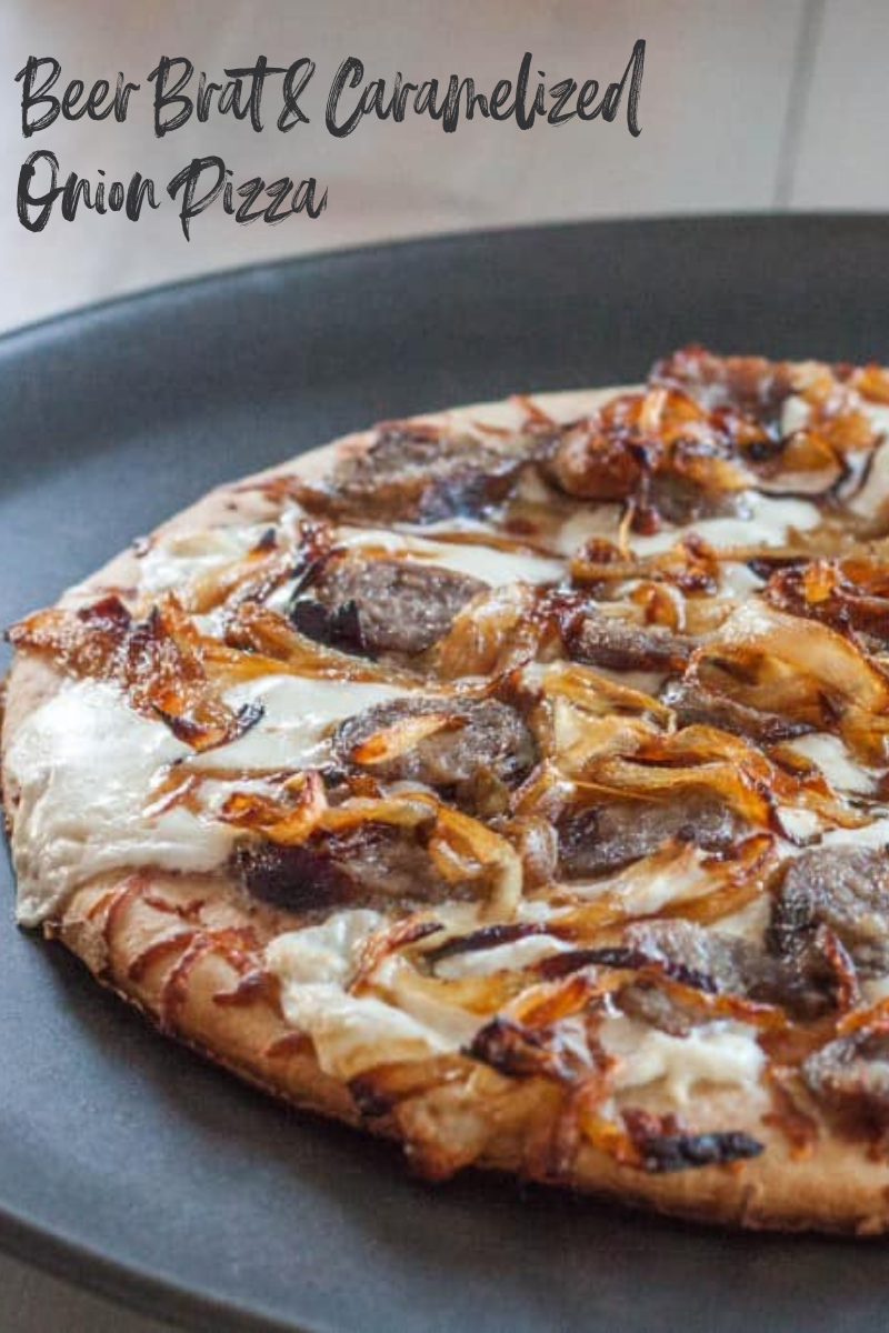 Beer brat and caramelized onion pizza on black platter