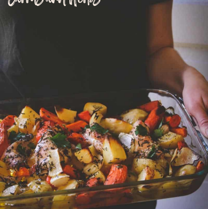 Baked chicken potatoes carrots and herbs in glass pan