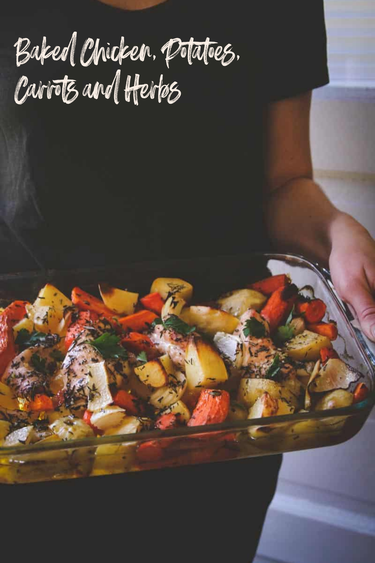 Baked chicken potatoes carrots and herbs in glass pan