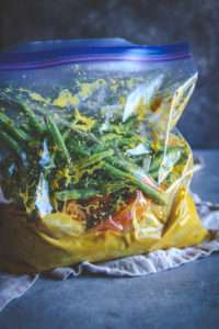 Turmeric chicken and veggies marinating in large Ziploc bag