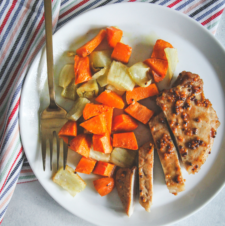 Pork chop, sweet potato, fennel on white plate with fork