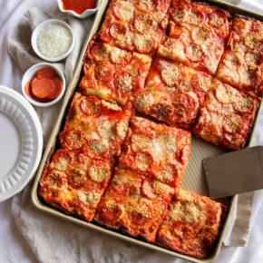 Pizza in a baking sheet cut into squares