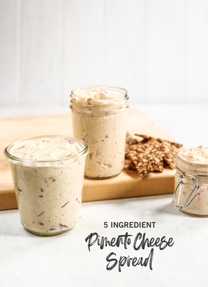 Pimento cheese spread in glass jar with crackers and baord