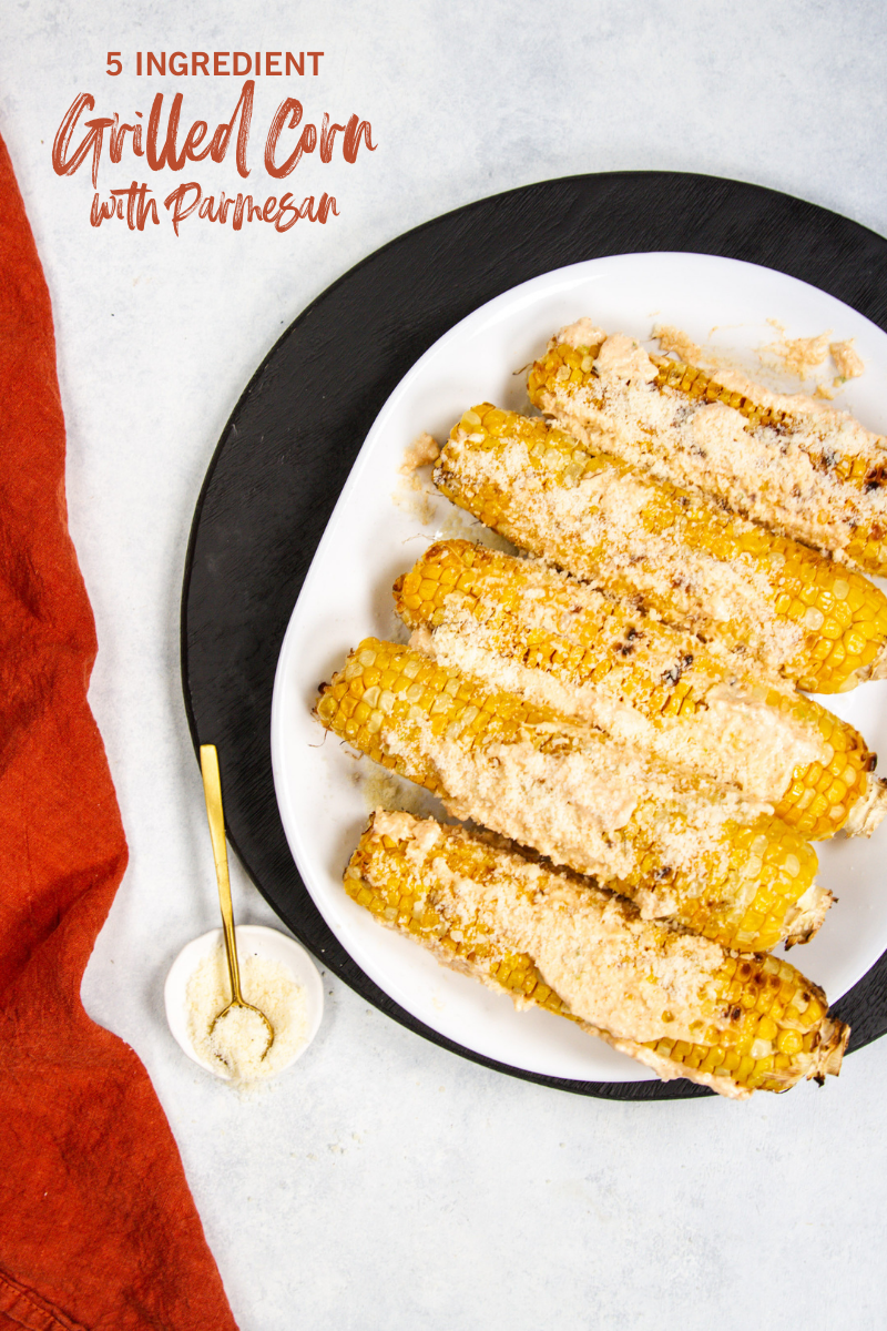 Grilled corn with parmesan on a white platter
