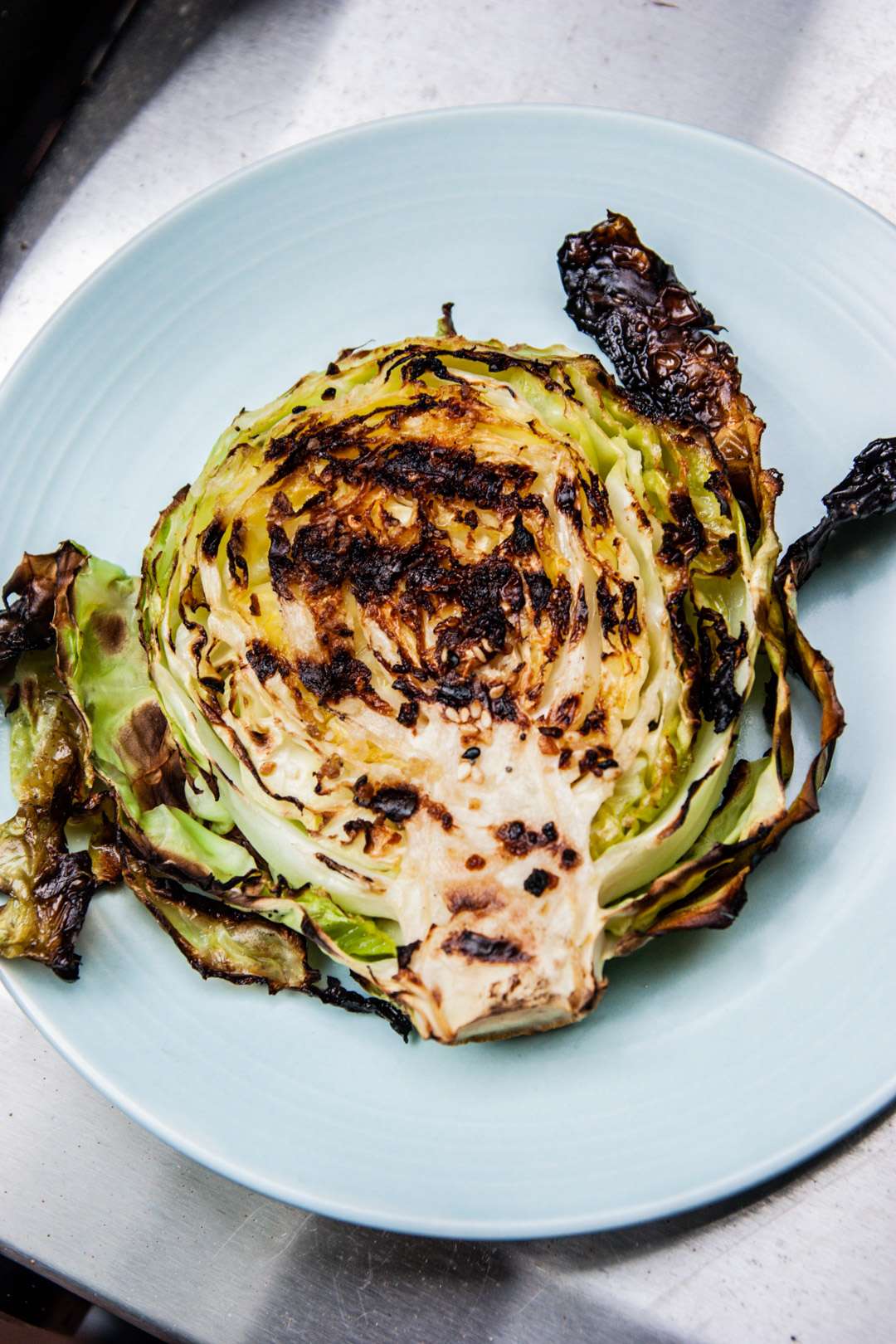 Grilled cabbage steak on light blue plate