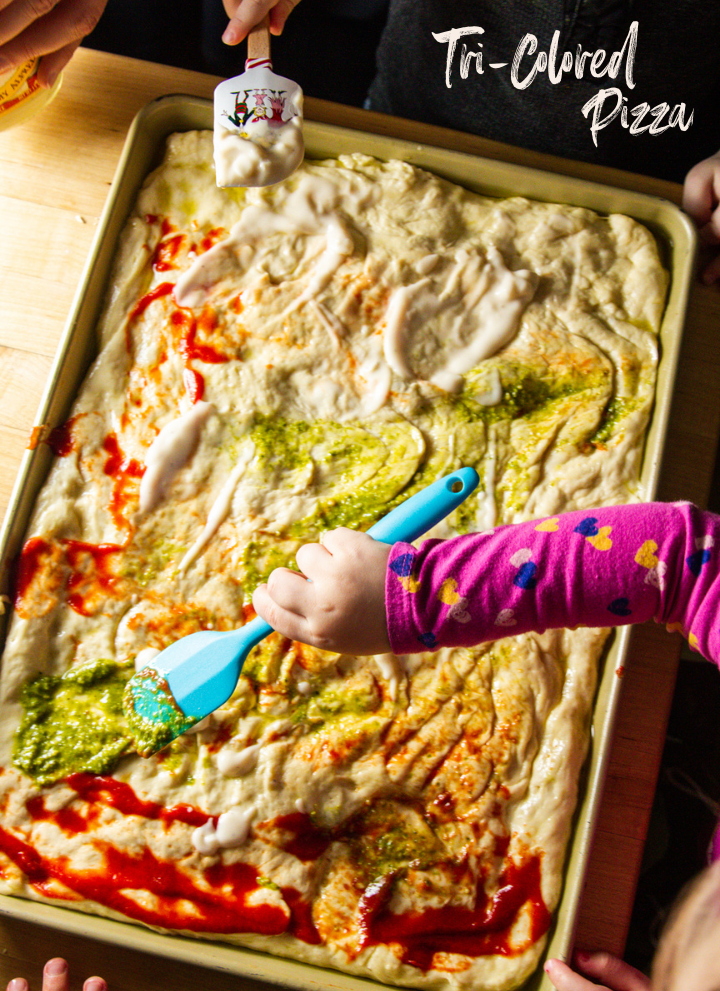 Kids spreading three sauces on pizza dough