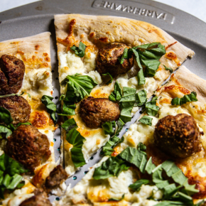 Slice of pizza with meatball, ricotta and Caesar